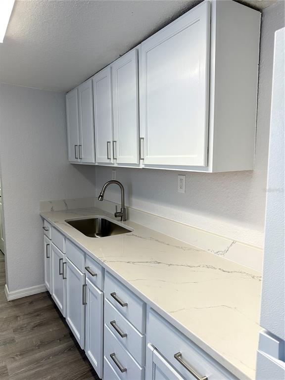 A kitchen features white cabinets, a stainless steel sink, and a white marble-patterned countertop — 4214 E PALIFOX STREET, TAMPA, FL