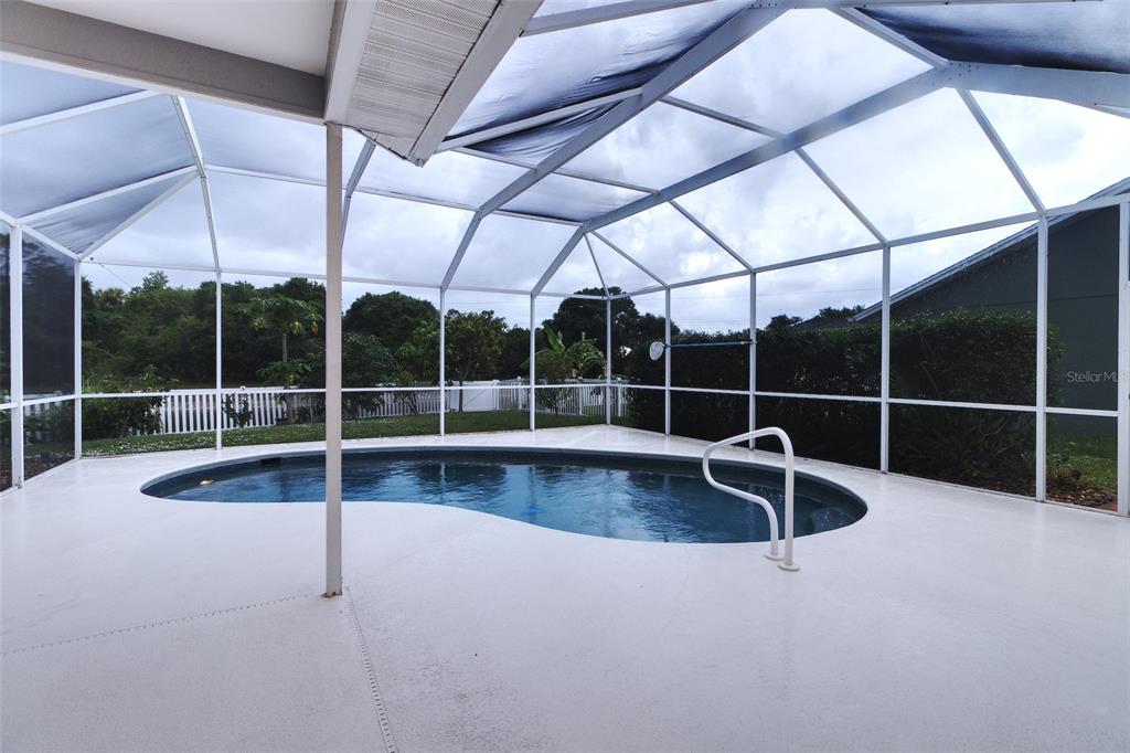 A screened-in pool enclosure with a kidney-shaped pool and white concrete decking — 6734 60TH STREET CIRCLE E, PALMETTO, FL
