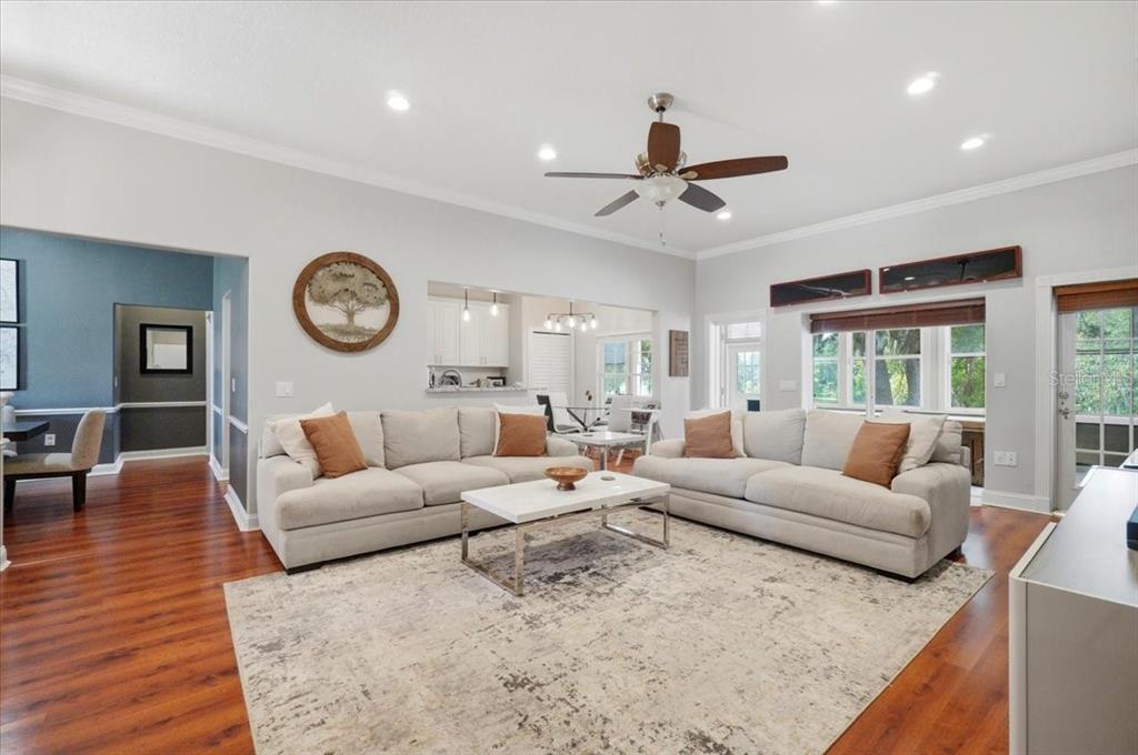 A living room features two beige sofas, a white coffee table, and hardwood flooring — 448 LAKE HARRIS DRIVE, LAKELAND, FL