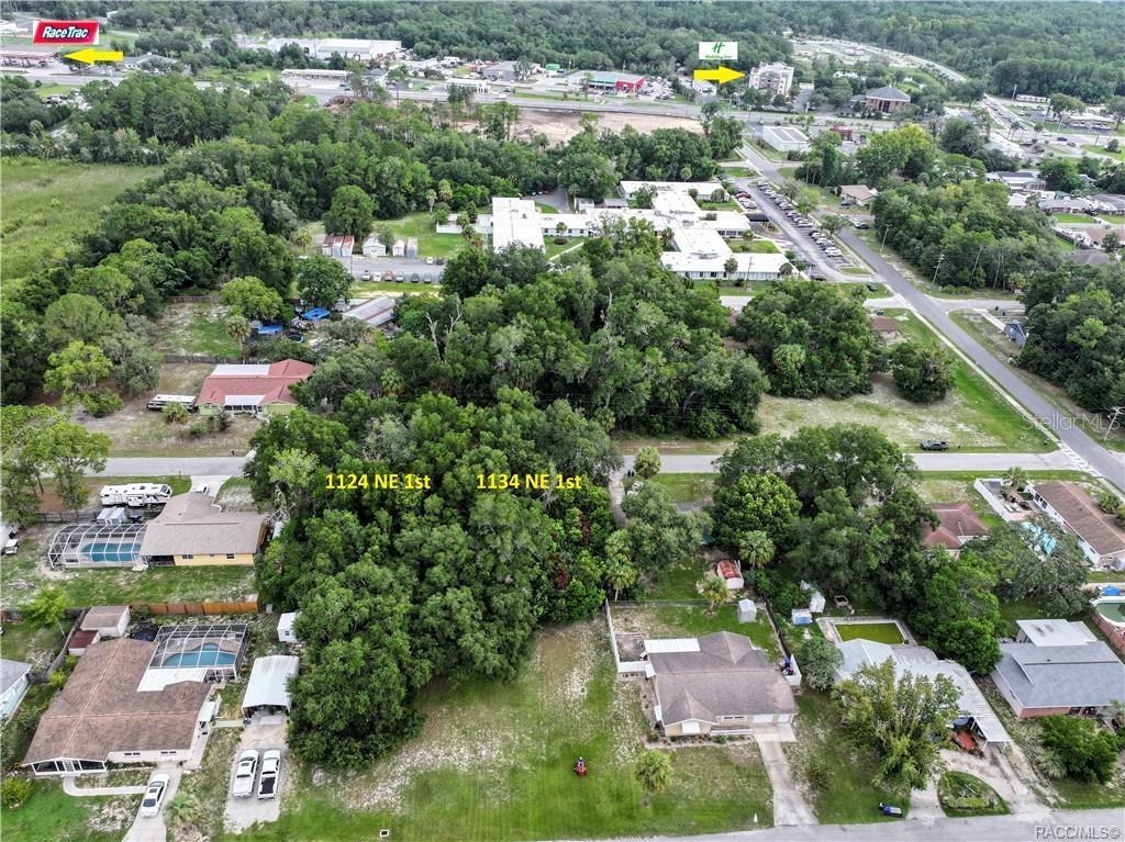 This aerial view shows two adjacent wooded lots situated between residential homes and a road — 1134 NE 1ST TERRACE, CRYSTAL RIVER, FL