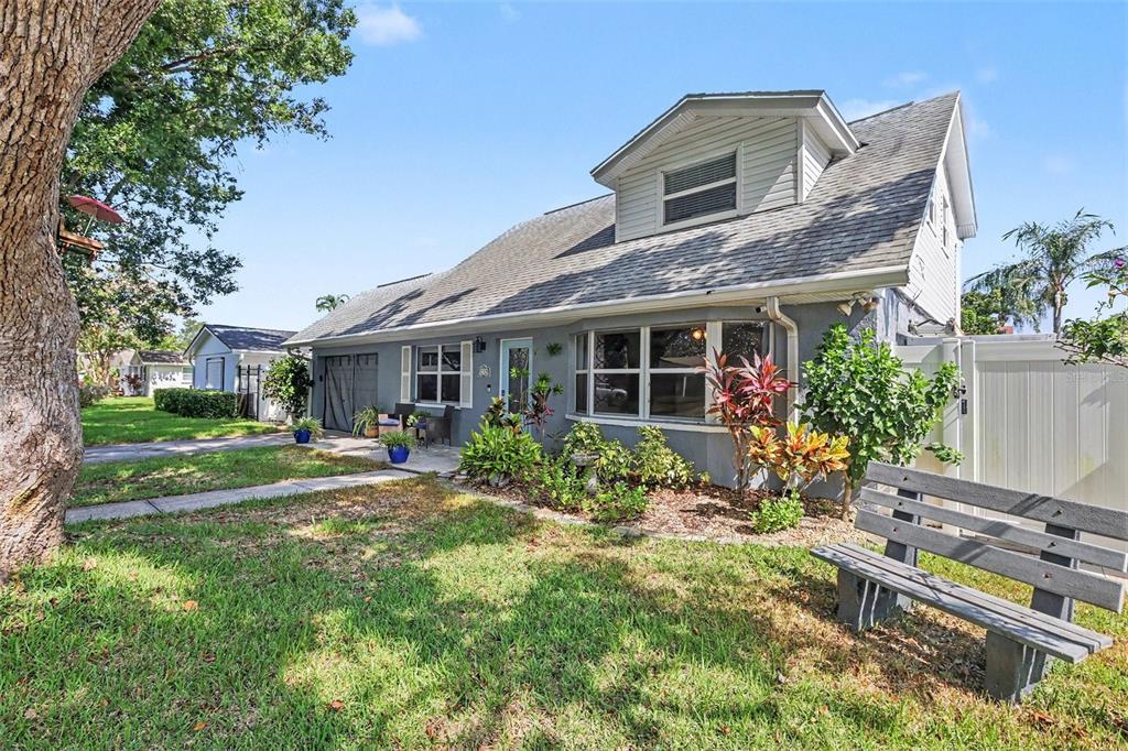 A gray two-story house with a front lawn, a wooden bench, and a large tree — 12321 82ND AVE, SEMINOLE, FL