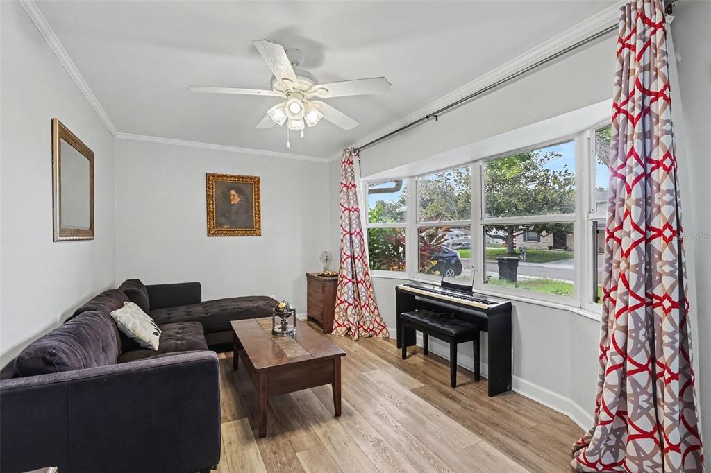 A living room features a dark sectional sofa, a wooden coffee table, and a digital piano — 12321 82ND AVE, SEMINOLE, FL