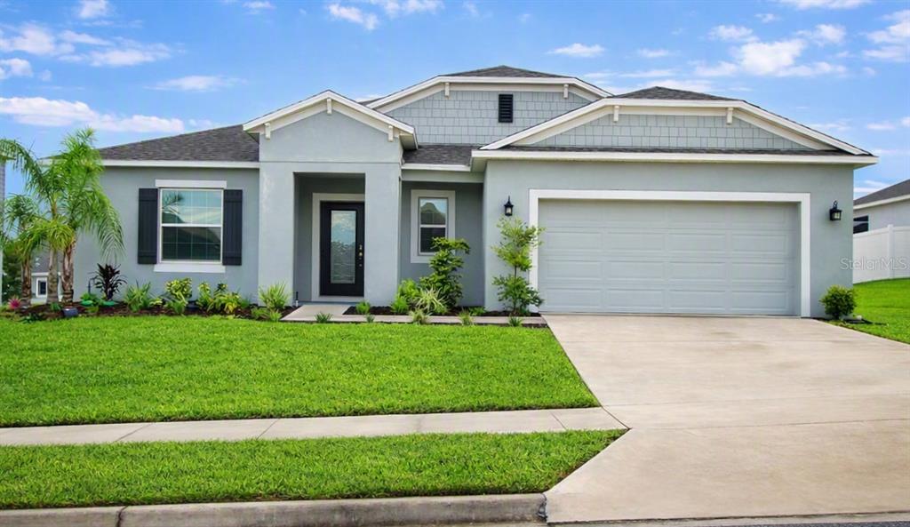 An aerial view of a single-story suburban house with a two-car garage and lawn — 516 INGLESIDE LANE, HAINES CITY, FL