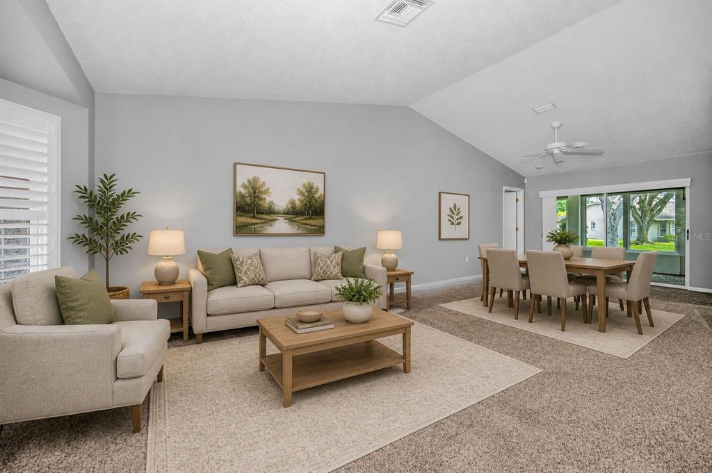 A living and dining room with neutral furniture, light gray walls, and vaulted ceilings — 1300 FALLOWFIELD DRIVE, TRINITY, FL