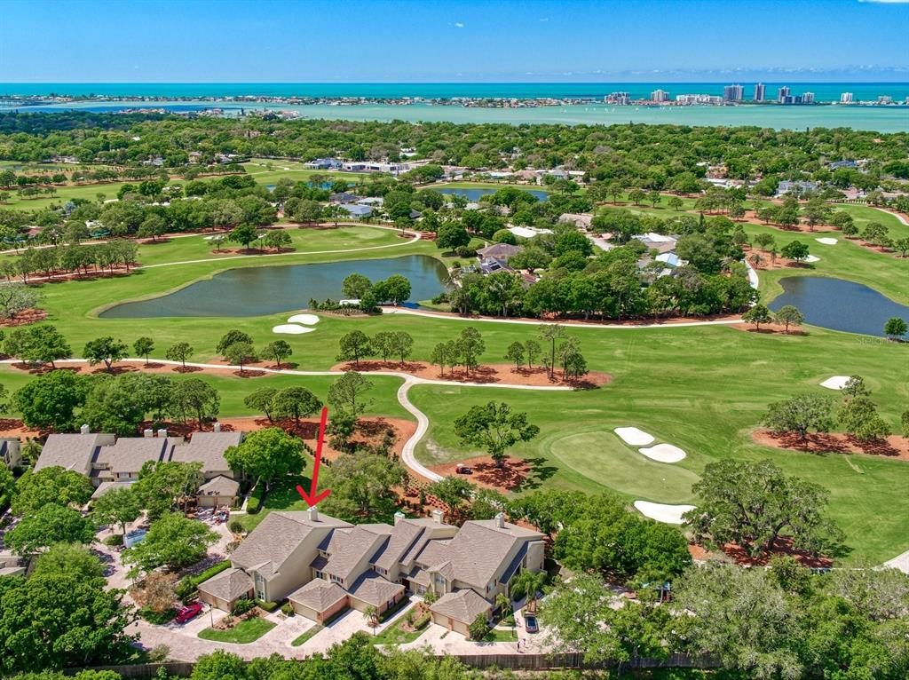An aerial view of a multi-unit residential building situated next to a golf course — 75 PELICAN PLACE, BELLEAIR, FL