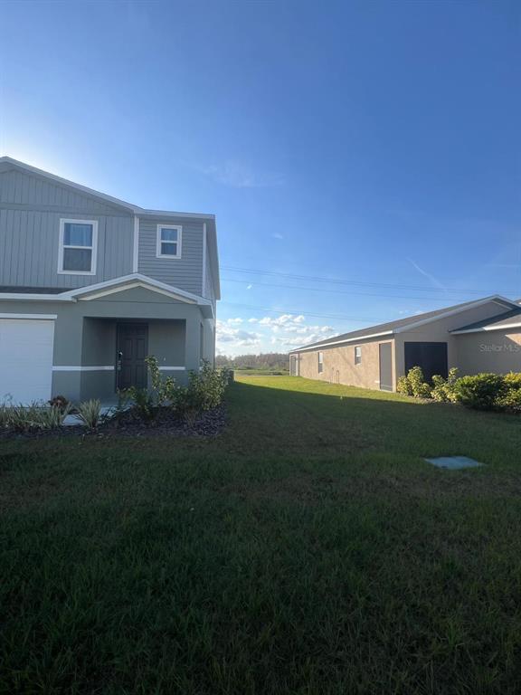 A two-story house with a gray exterior stands next to a single-story house — 1926 GOLDEN BEAK DRIVE, EAGLE LAKE, FL