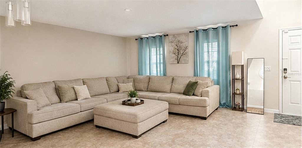 A living room features a large beige sectional sofa, a matching ottoman, and teal curtains — 528 STONEWALL AVENUE, HAINES CITY, FL