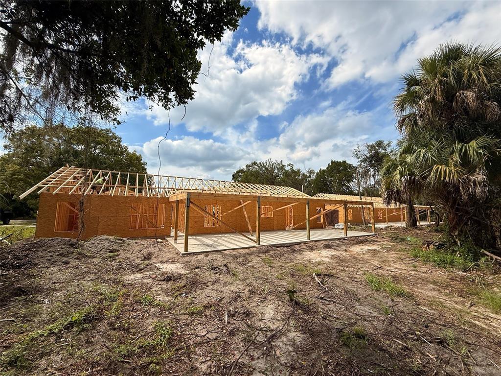 A wooden frame house under construction sits on a dirt lot with a covered porch — 101 YAWN AVENUE, INTERLACHEN, FL