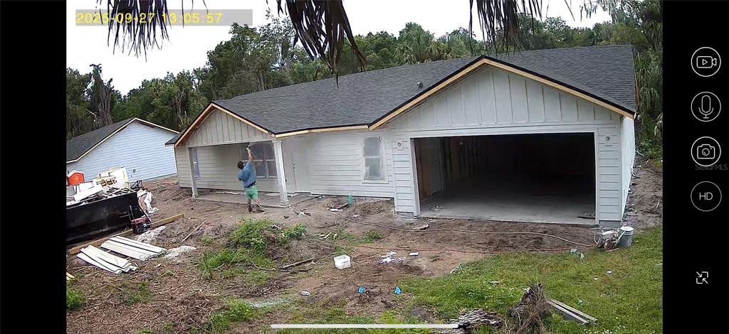 A person paints the exterior of a newly constructed white house with a garage — 101 YAWN AVENUE, INTERLACHEN, FL