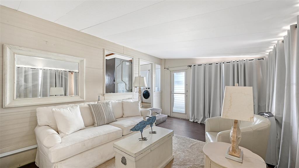 A living room features a white sofa, a coffee table, and light-colored wood-paneled walls — 36 TWIN SHORES BOULEVARD, LONGBOAT KEY, FL