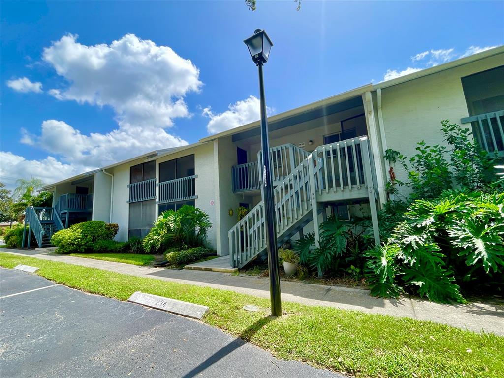 A screened-in porch overlooks a pond filled with lily pads and surrounding trees — 11201 122ND AVENUE UNIT 234, LARGO, FL