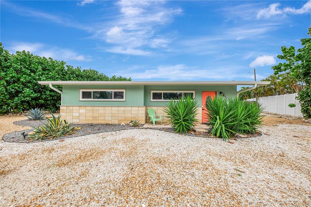 A single-story house with light green siding, stone accents, and a coral-colored front door — 4626 GLEASON AVENUE, SARASOTA, FL