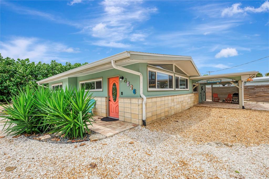 A single-story house with light green siding, a coral door, and a gravel front yard — 4626 GLEASON AVENUE, SARASOTA, FL