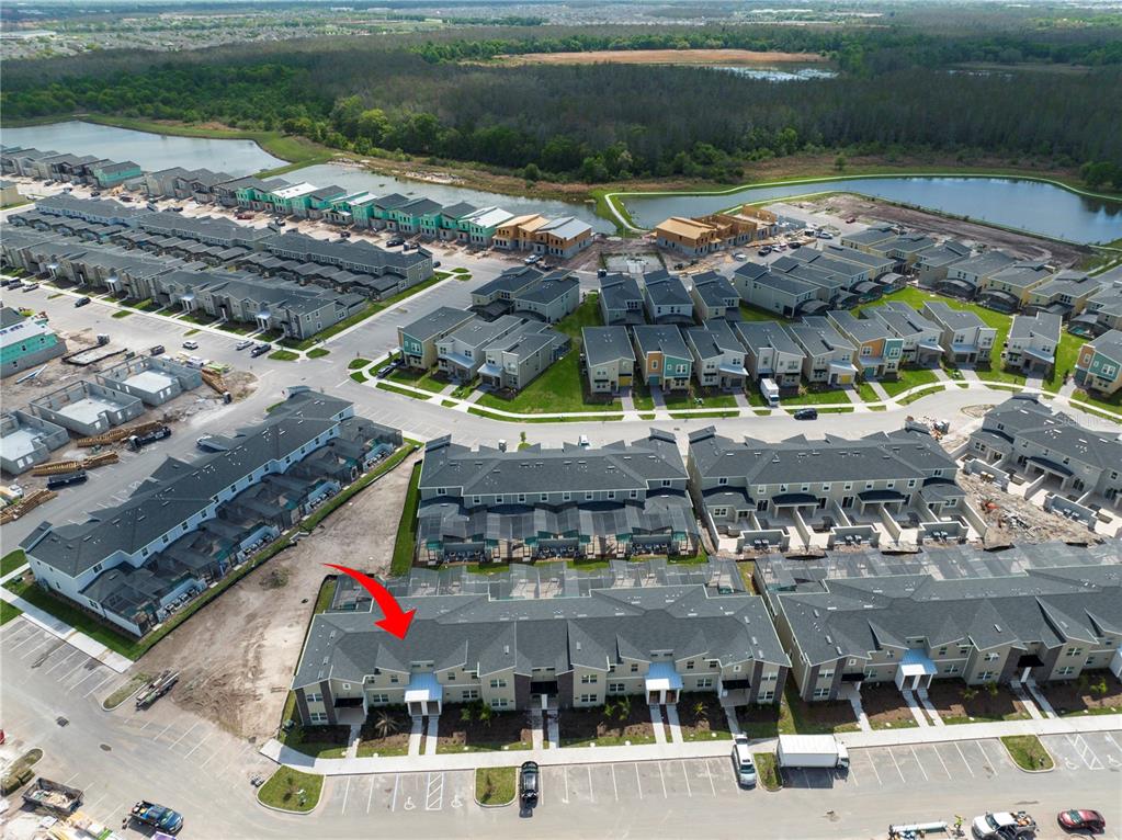An aerial view shows a residential neighborhood with townhouses, construction sites, and nearby ponds — 2967 PENELOPE LOOP, KISSIMMEE, FL