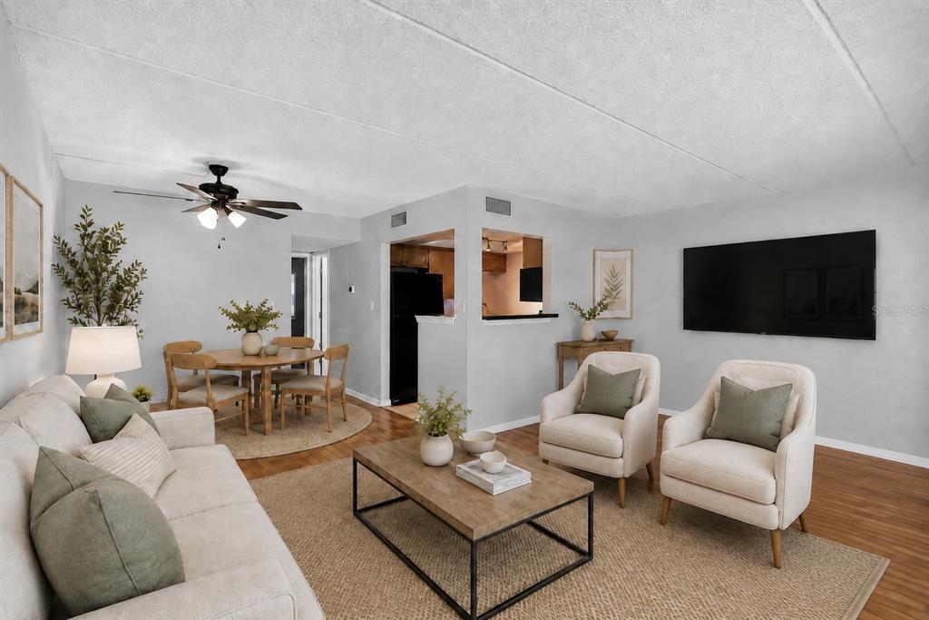 A living room and dining area feature light walls, wood flooring, and neutral-toned furniture — 285 LEWFIELD CIRCLE UNIT 285, WINTER PARK, FL