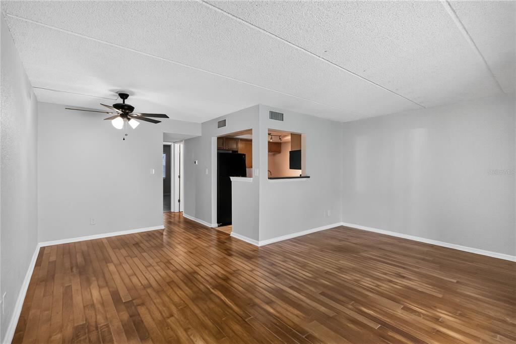 An empty living room with light gray walls, wood-look flooring, and a ceiling fan — 285 LEWFIELD CIRCLE UNIT 285, WINTER PARK, FL