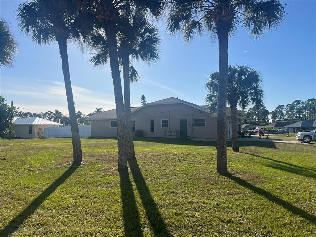 The exterior of a single-story house with palm trees in a grassy yard — 3645 SLAYTON AVENUE, NORTH PORT, FL