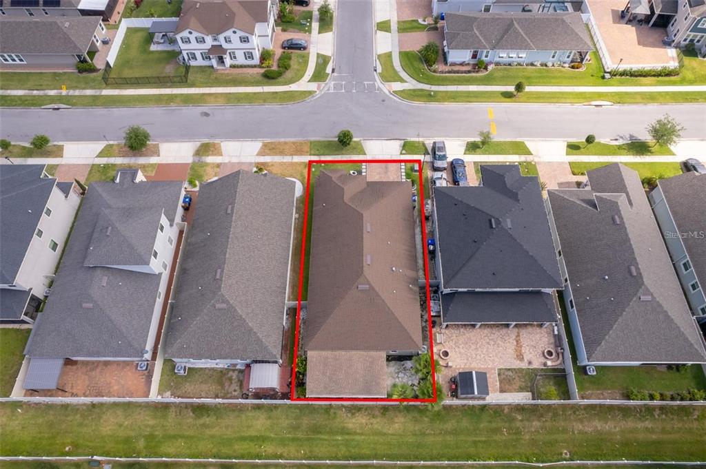 An aerial view shows a single-family home outlined in red within a suburban neighborhood — 2780 AVIAN LOOP, KISSIMMEE, FL
