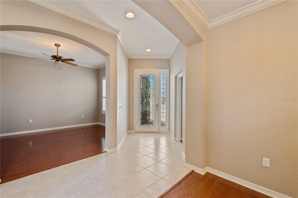 An entryway with tile flooring leads to a front door with decorative glass panels — 2464 LAUREL GLEN DRIVE, LAKELAND, FL