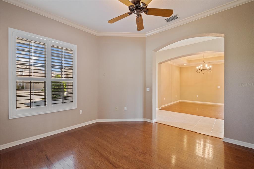 An empty room with hardwood floors, a ceiling fan, and an arched entryway to another room — 2464 LAUREL GLEN DRIVE, LAKELAND, FL