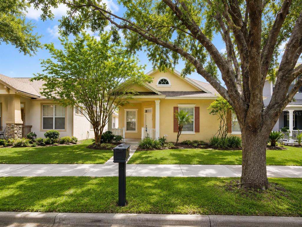 A yellow single-story house with a front porch, a mailbox, and a large tree — 12947 RUNSWICK AVENUE, WINDERMERE, FL