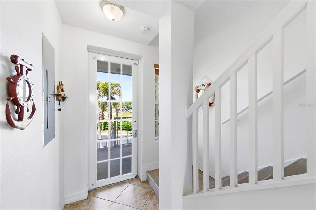 An entryway features a white door with glass panes, tile flooring, and a white staircase — 601 BAHIA BEACH BOULEVARD, RUSKIN, FL