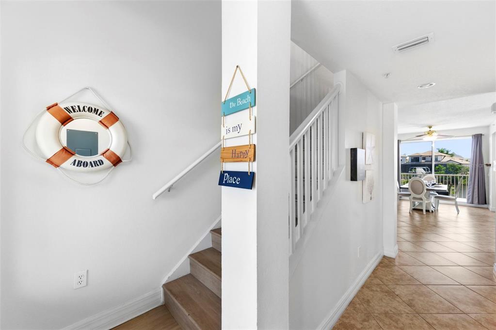 An entryway features a staircase with wood treads, a life preserver decoration, and tiled floors — 601 BAHIA BEACH BOULEVARD, RUSKIN, FL