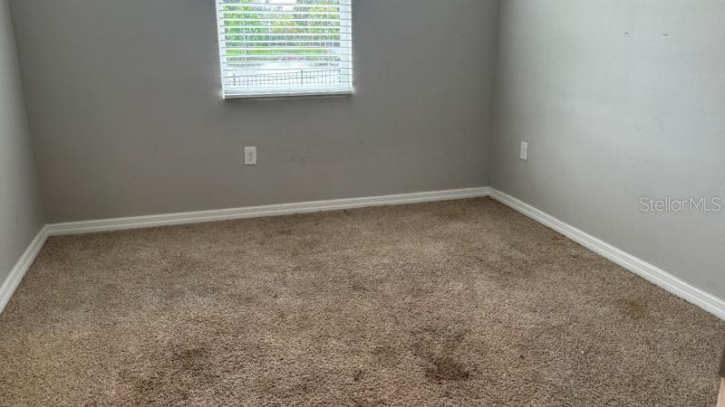 An empty bedroom features gray walls, beige carpeting, and a window with white blinds — 16453 WOODSIDE GLEN, PARRISH, FL