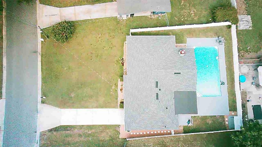 An aerial view shows a house with a swimming pool, a driveway, and a fenced yard — 1337 LEE COURT, LEESBURG, FL