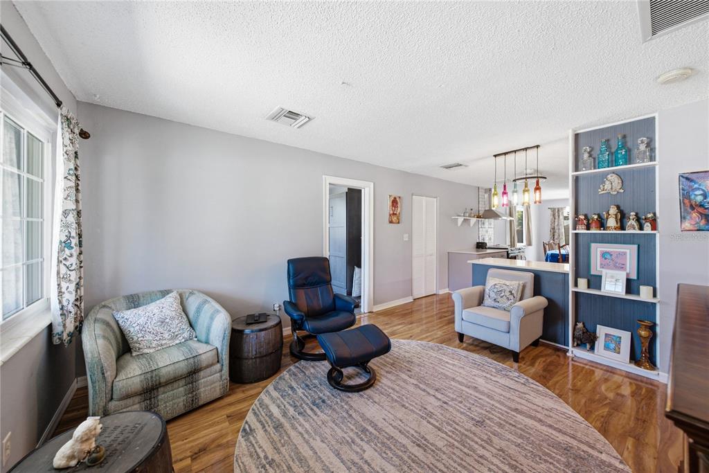 A living room with hardwood floors, a round area rug, and a built-in display shelf — 5326 6TH AVENUE S, ST PETERSBURG, FL