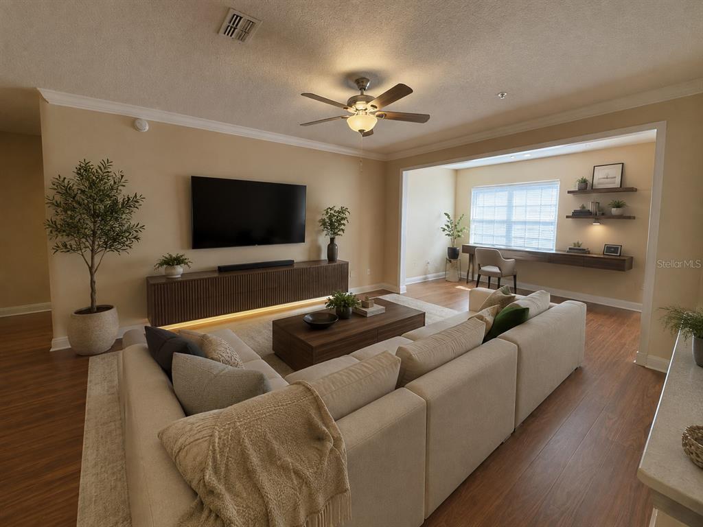 A living room with wood-look flooring, a ceiling fan, and a recessed window area — 225 SOUTHERN PECAN CIRCLE UNIT 208, WINTER GARDEN, FL