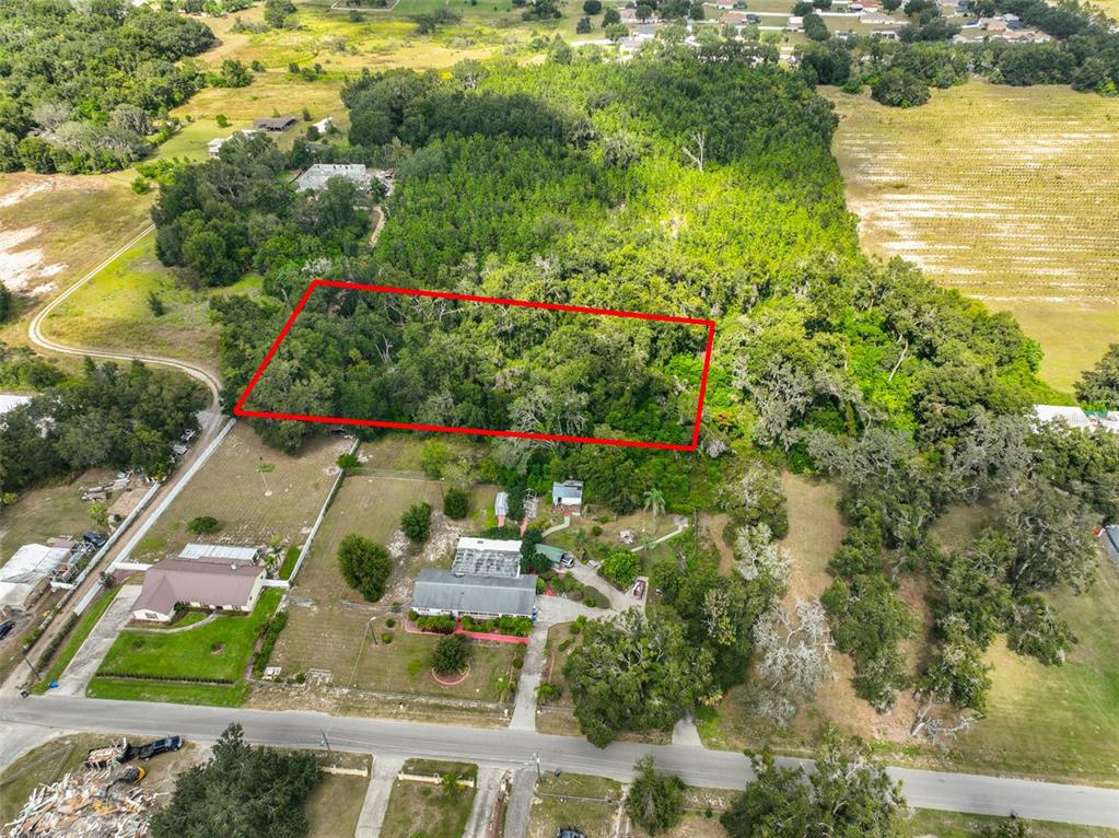 An aerial view shows a rectangular plot of land outlined in red behind a house — STARK ROAD, SEFFNER, FL
