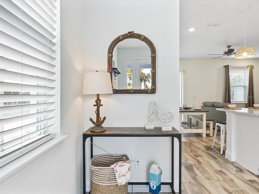 A coastal-themed entryway features a console table, rope-framed mirror, and a woven storage basket — 8217 SURF STREET, KISSIMMEE, FL