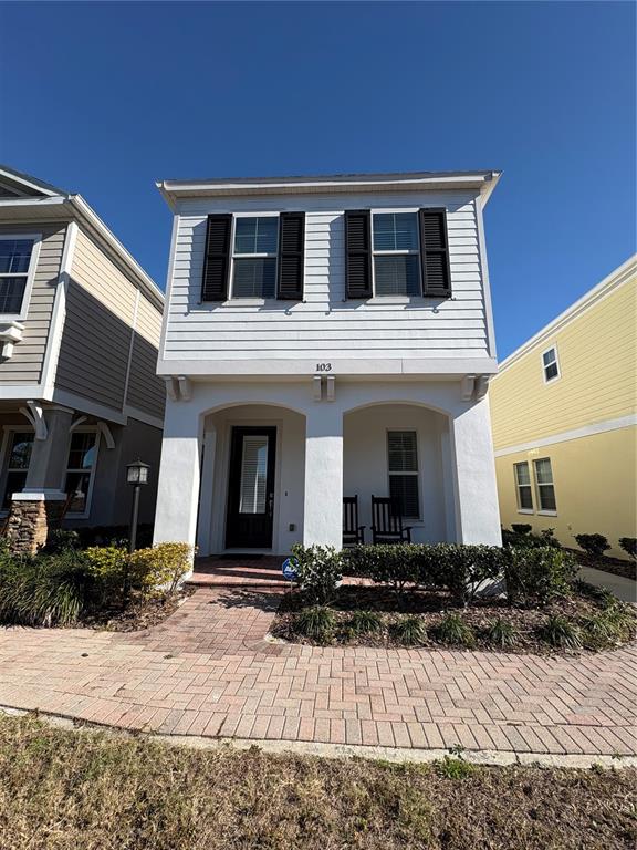 A two-story house with white siding, a covered front porch, and a brick paver walkway — 103 CUTLASS WAY, OLDSMAR, FL