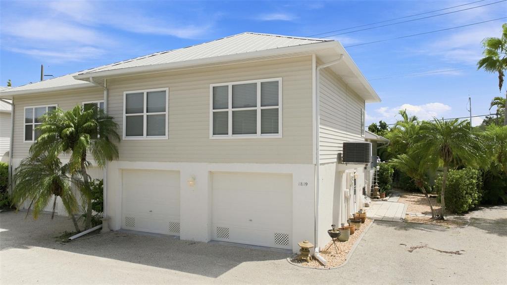 An entryway with a white door, tiled floors, and a view into a kitchen area — 1819 HIGHLAND ROAD, OSPREY, FL