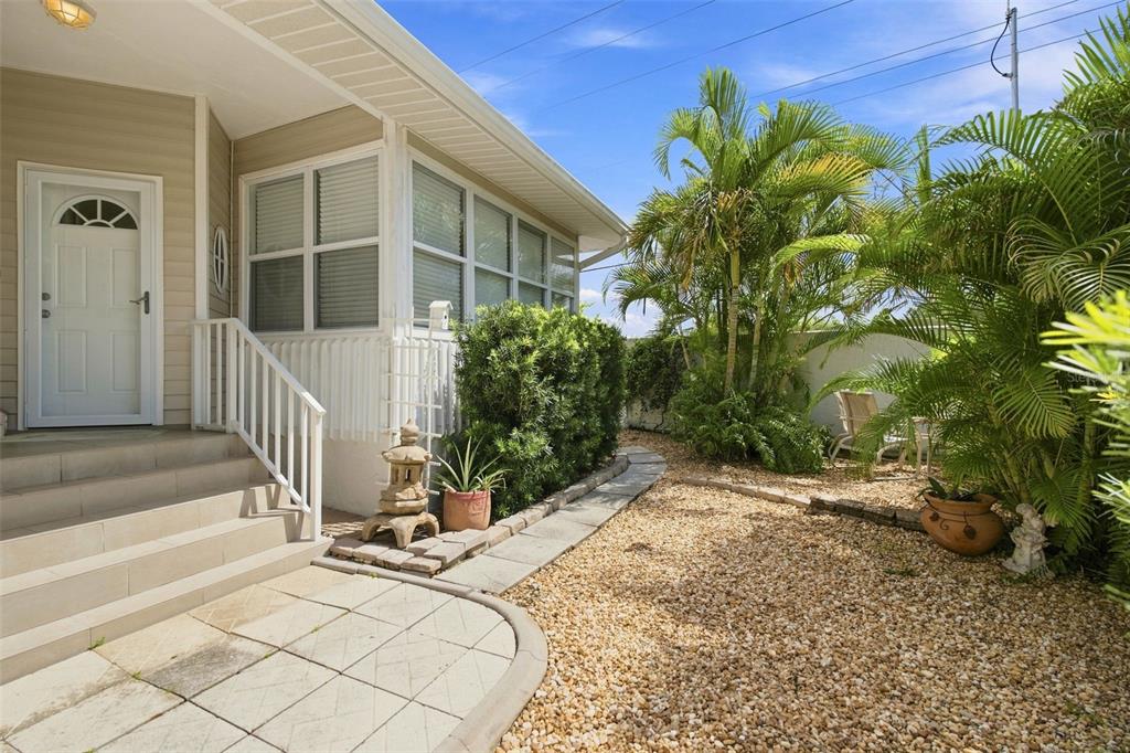 A living room features a tray ceiling, tile flooring, a white sofa, and a large window — 1819 HIGHLAND ROAD, OSPREY, FL