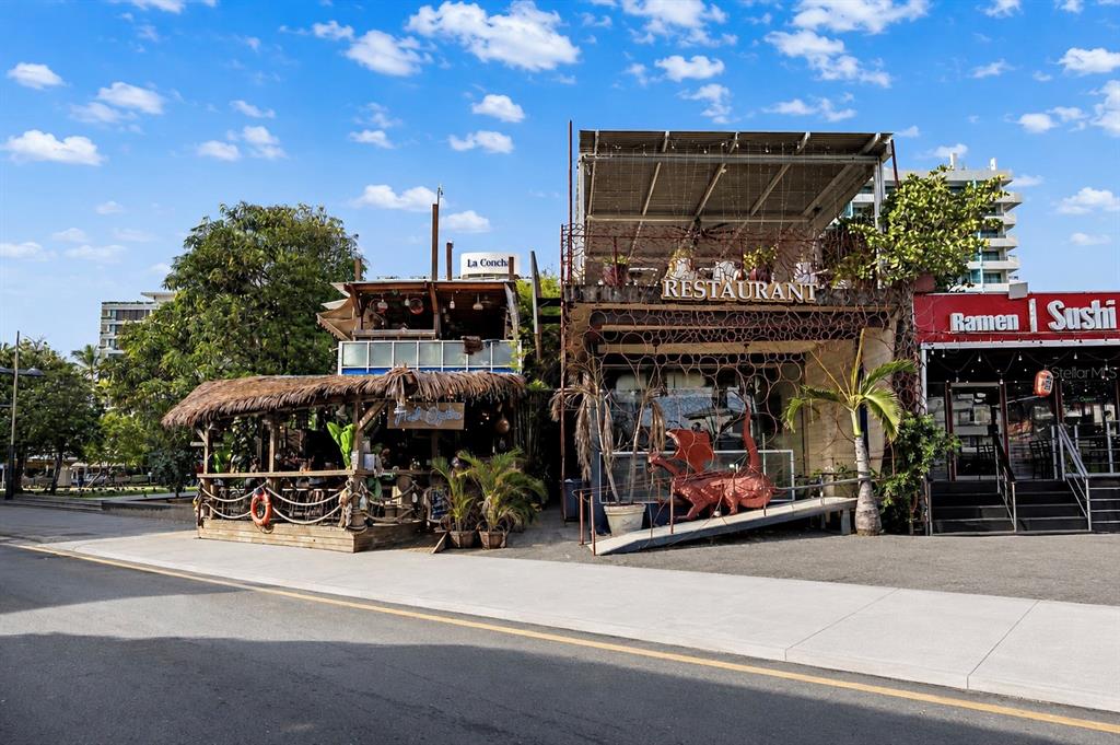 An outdoor covered patio features a winding mosaic bench, dining tables, and large ceiling fans — 1105 MAGDALENA AVENUE UNIT Condal, SAN JUAN, PR