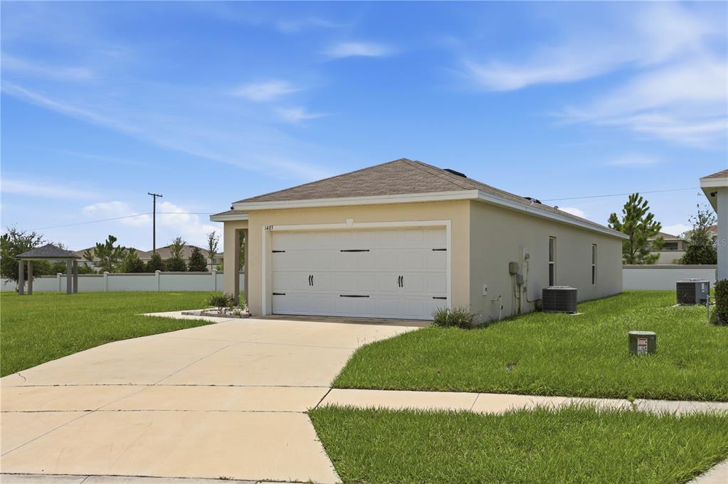 An empty room with light gray walls, tan tile flooring, and two windows — 1403 MADISON CIRCLE, HAINES CITY, FL