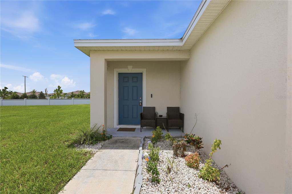 An open-concept living area with light gray walls, tile flooring, and a kitchen breakfast bar — 1403 MADISON CIRCLE, HAINES CITY, FL
