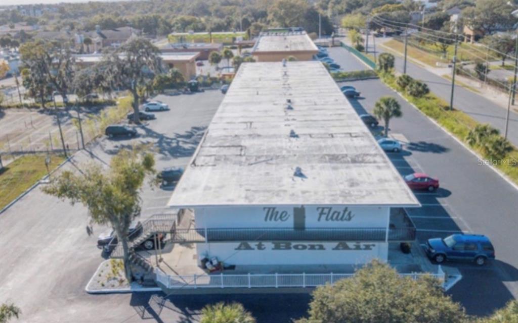 An aerial view shows a long, flat-roofed apartment building with parking lots on both sides — 515 BON AIR STREET UNIT 1A, LAKELAND, FL