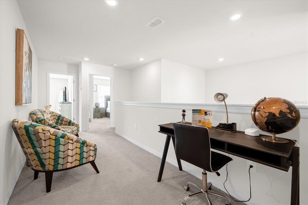 A carpeted loft area features a desk, a globe, and two patterned armchairs — 7260 OAKMOSS LOOP, DAVENPORT, FL