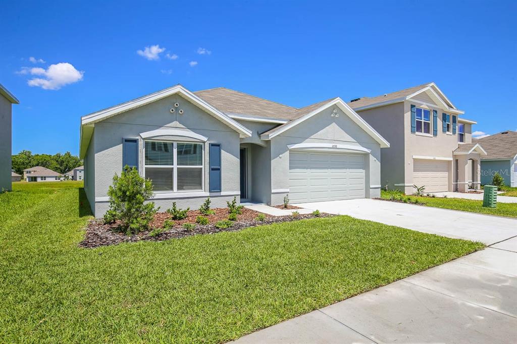 A kitchen features dark cabinets, stainless steel appliances, and a granite-topped island with a sink — 16530 WINDMILL FORGE PASS, WIMAUMA, FL