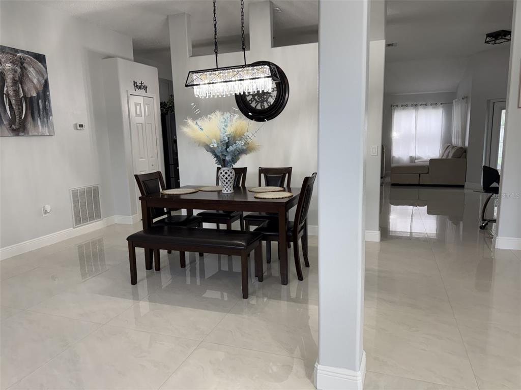 A view from an entryway into a dining area with tiled floors and arched openings — 14 WAYLAND PLACE, PALM COAST, FL