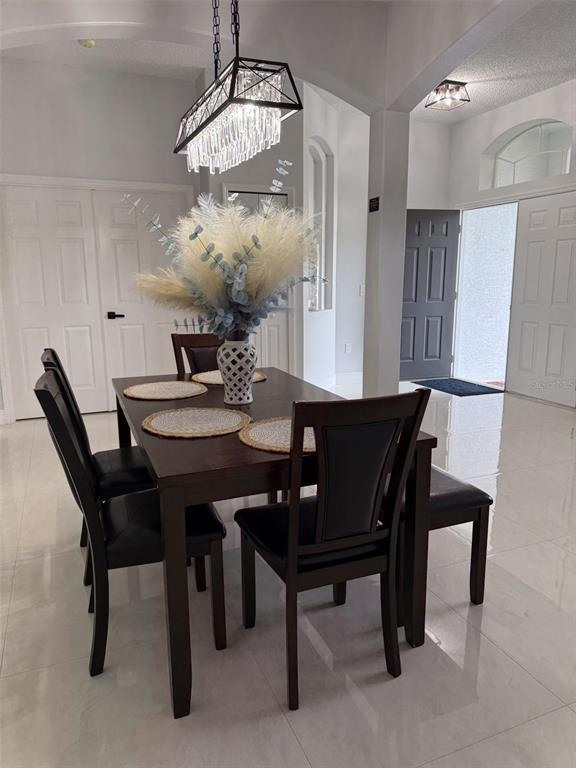 A modern kitchen features gray cabinets, a white quartz island, and three hanging pendant lights — 14 WAYLAND PLACE, PALM COAST, FL