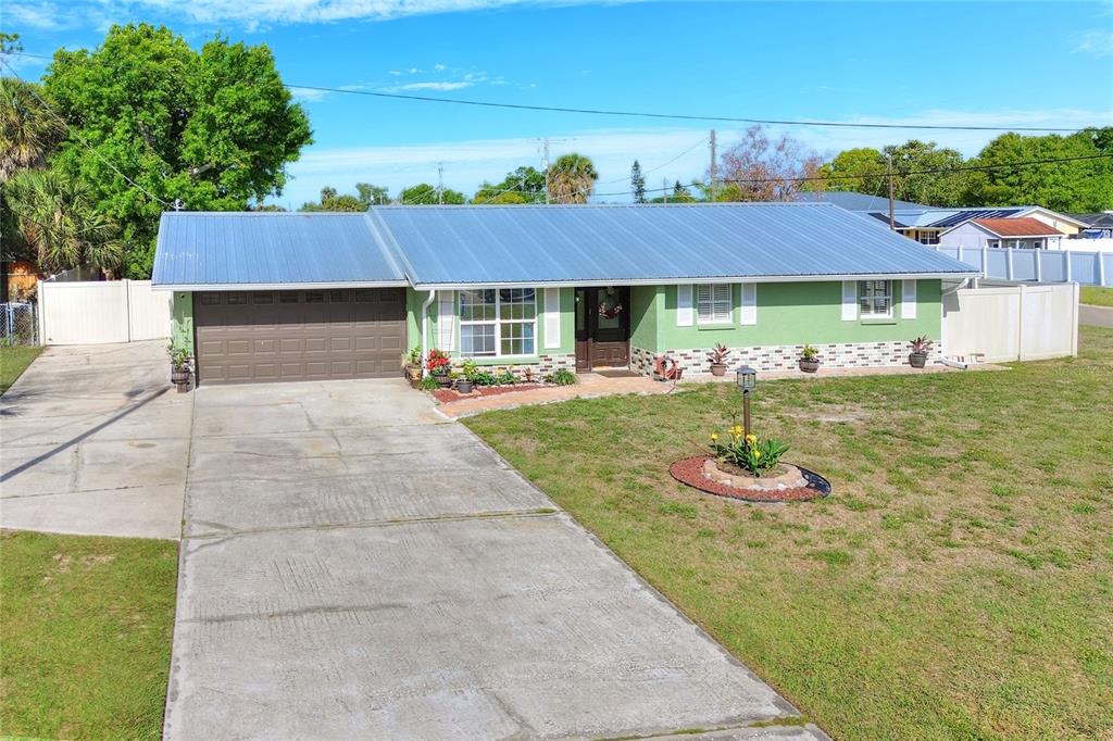 A single-story house with a green exterior, metal roof, and attached garage — 6108 FAIRWAY BOULEVARD, APOLLO BEACH, FL