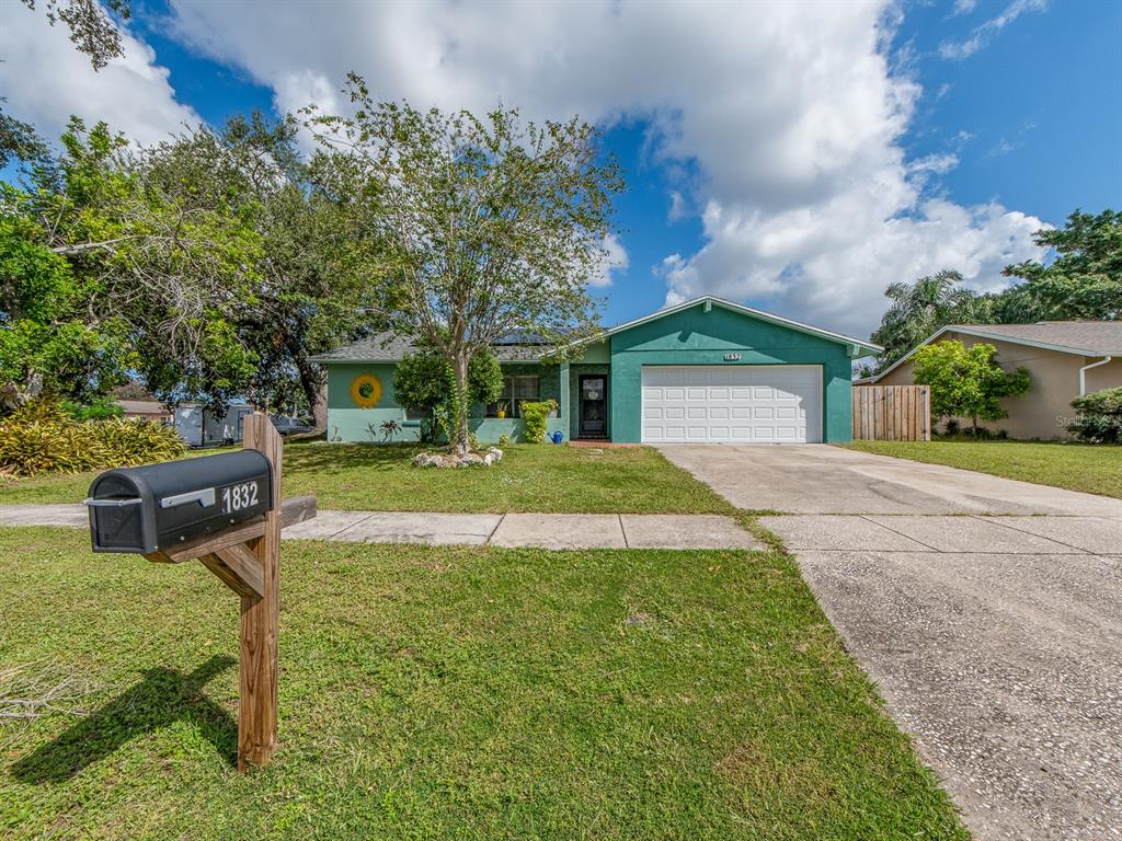 A single-story green house with a two-car garage and a mailbox in the front yard — 1832 SETON DRIVE, CLEARWATER, FL