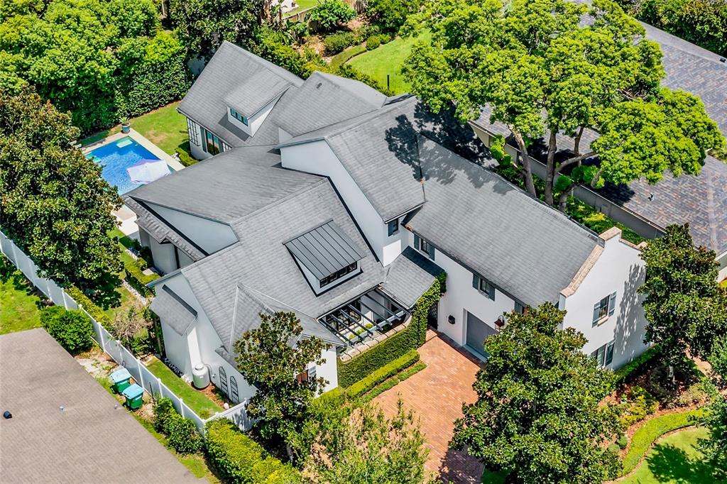 An aerial view of a white multi-story house with a gray roof, pool, and brick driveway — 1597 OAKHURST AVENUE, WINTER PARK, FL