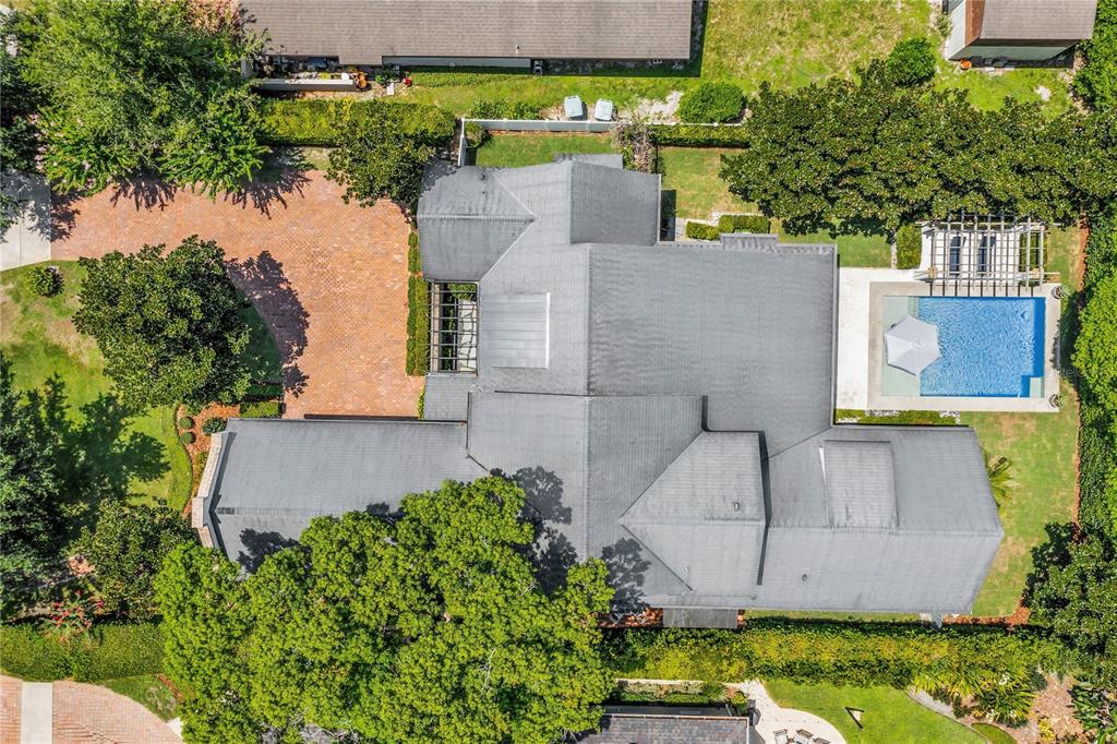 An aerial view shows a house with a gray roof, a pool, and a brick driveway — 1597 OAKHURST AVENUE, WINTER PARK, FL