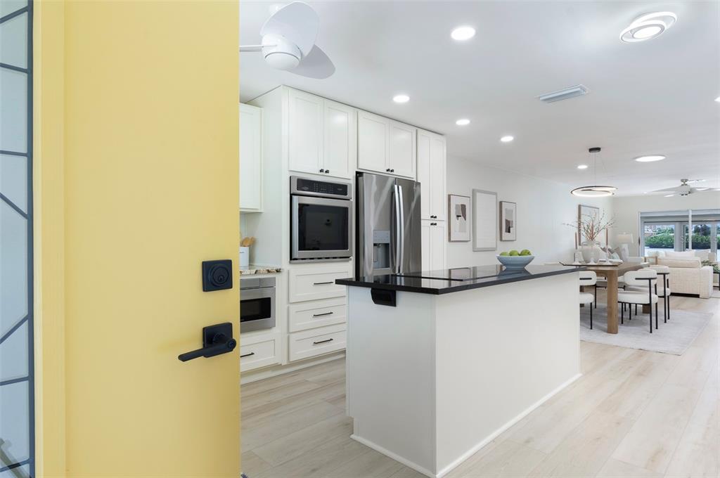 A bright kitchen with white cabinetry, stainless steel appliances, and a black island countertop — 382 BOCA CIEGA POINT BOULEVARD S, ST PETERSBURG, FL