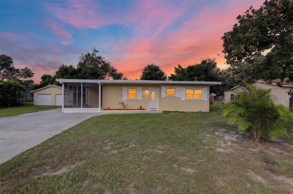 A single-story house with a screened-in porch, a concrete driveway, and a detached garage — 208 PALMYRA DRIVE, ORLANDO, FL